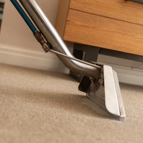 a hot water extraction wand cleaning a carpet